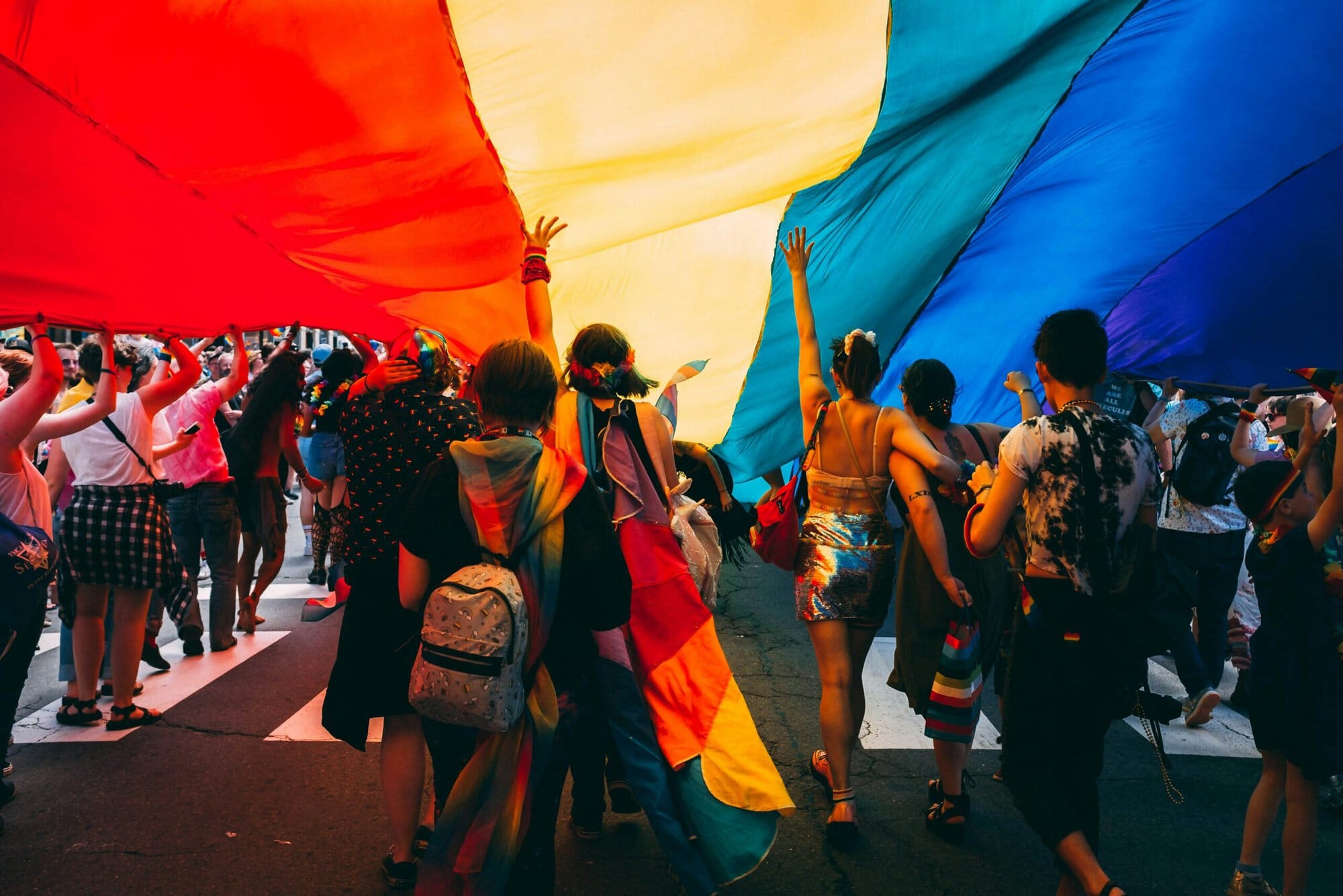 People marching with a Pride flag.